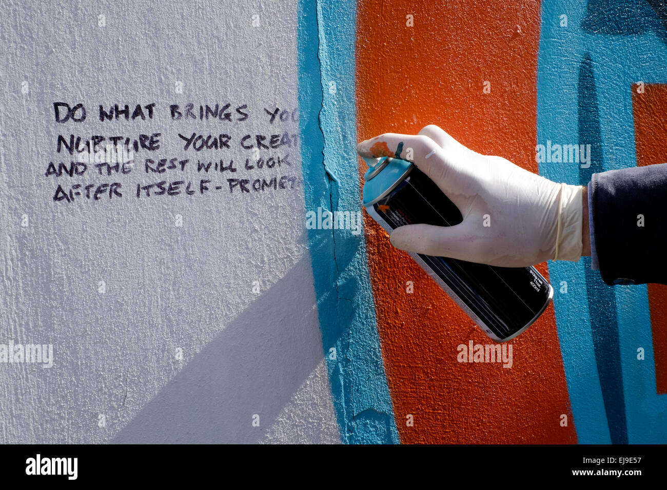 artist creating modern street art graffiti spray painted on a wall ...