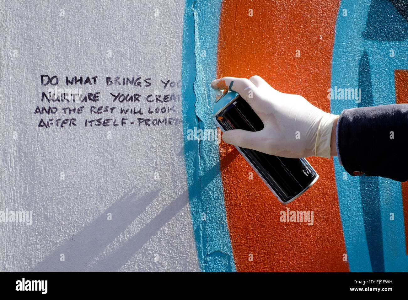 artist creating modern street art graffiti spray painted on a wall ...