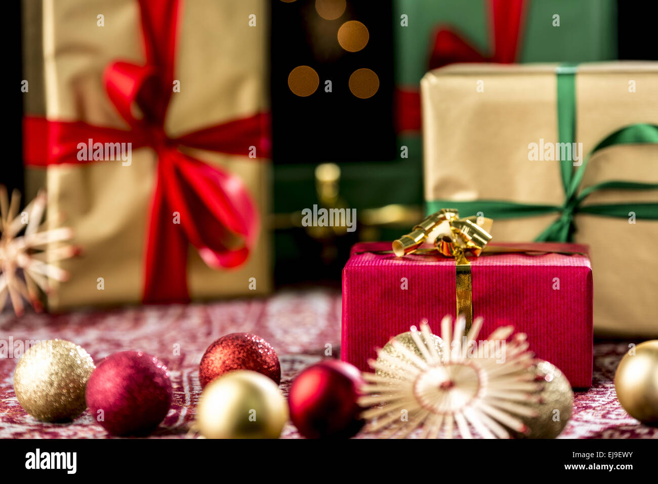 Red Christmas Gift Amidst Baubles and Stars Stock Photo