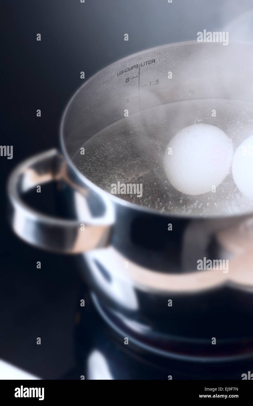 Boiling eggs on cooktop side view Stock Photo