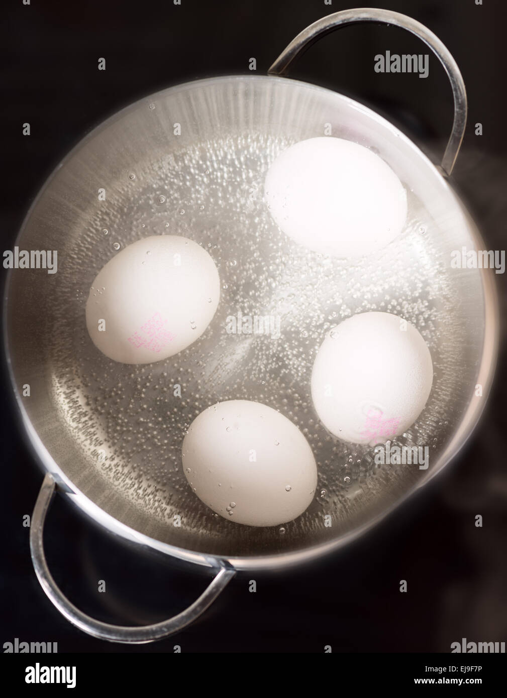 Boiling eggs on cooktop top view Stock Photo