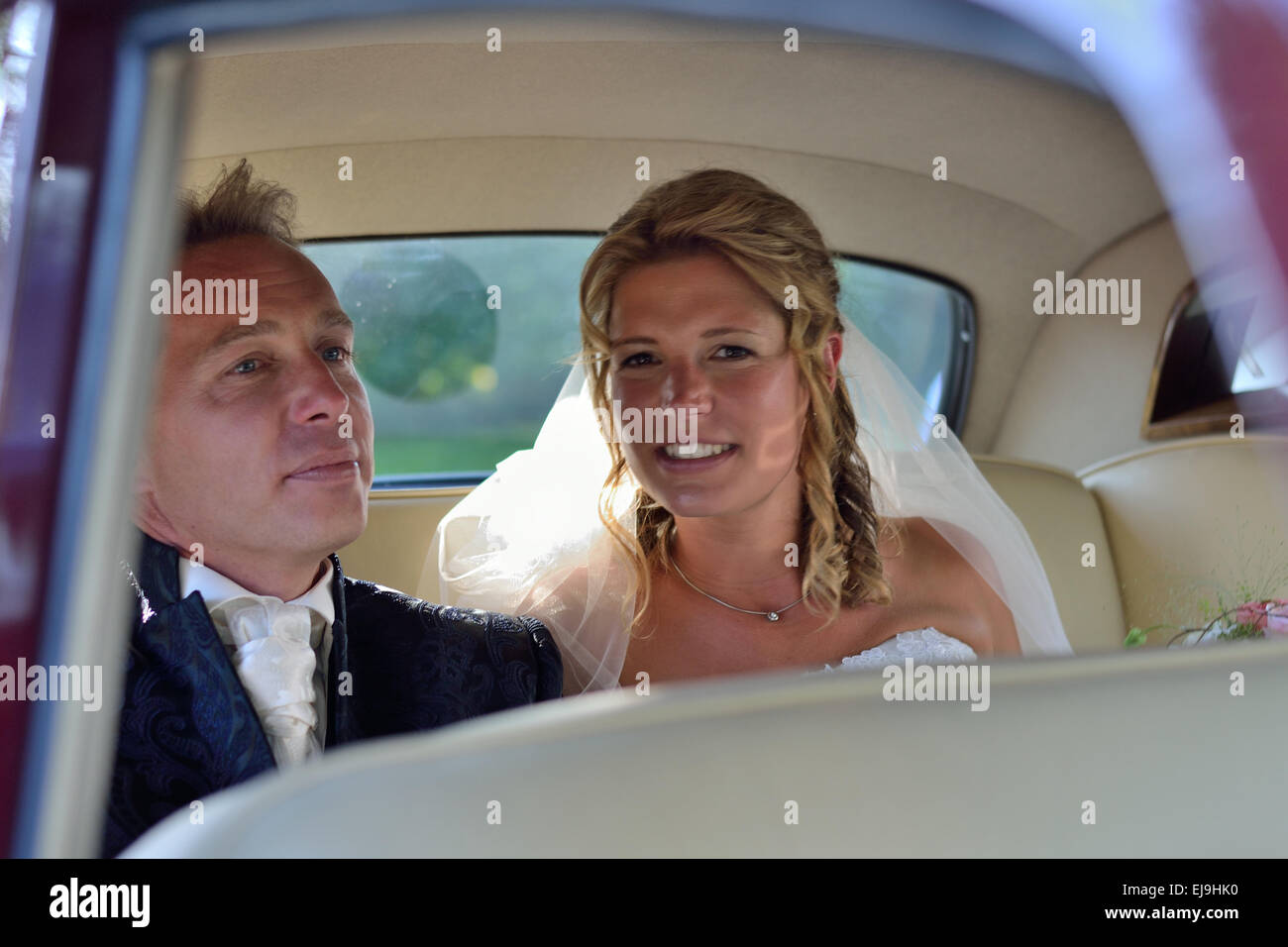 Bride and groom in wedding car Stock Photo - Alamy