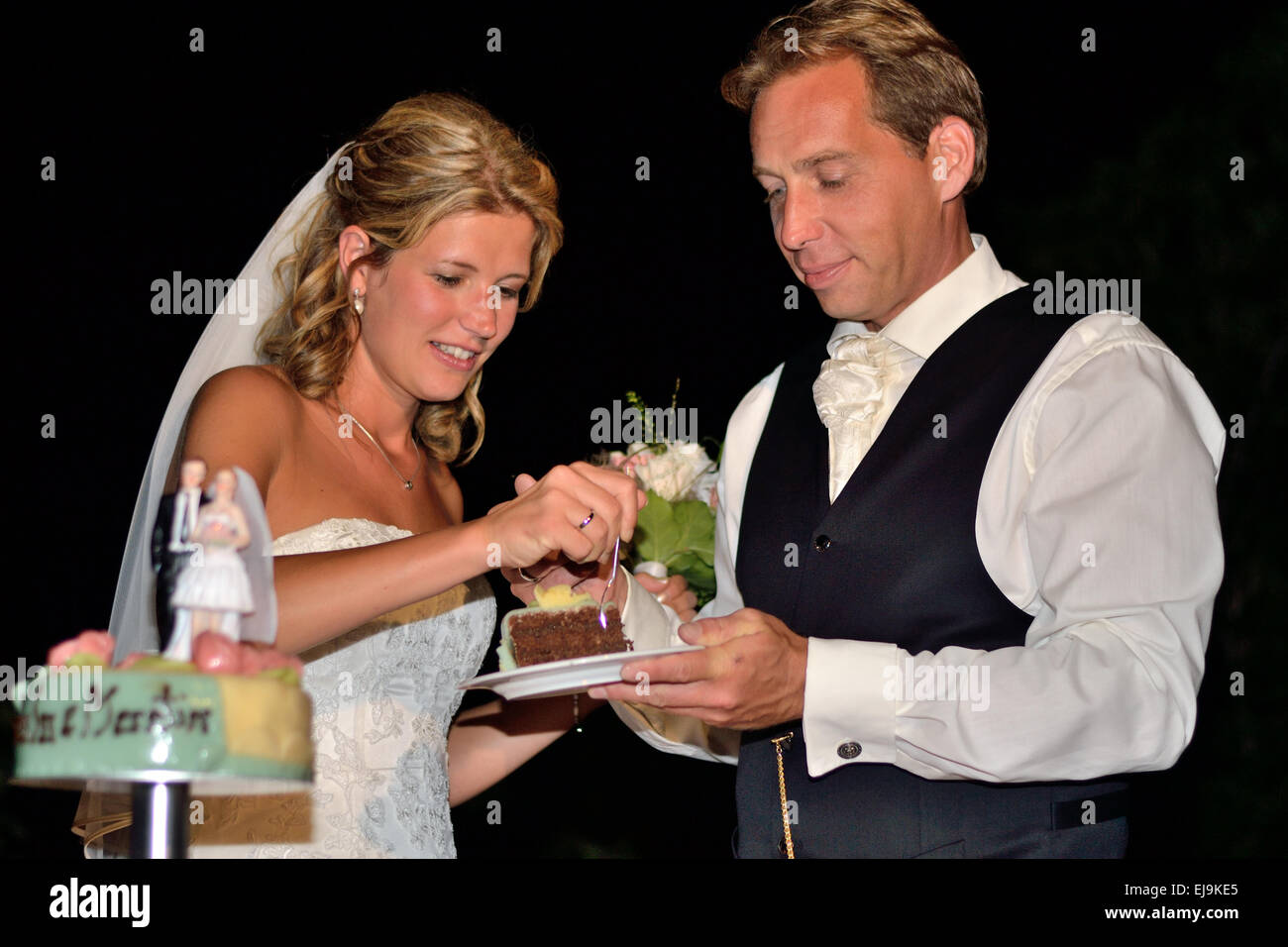Bride and groom eating wedding cake Stock Photo