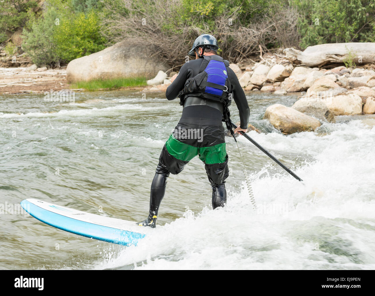 Expert stand up paddleboarder in white water Stock Photo