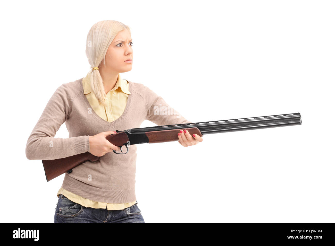 Furious young blond woman holding a shotgun ready to shoot isolated on white background Stock Photo