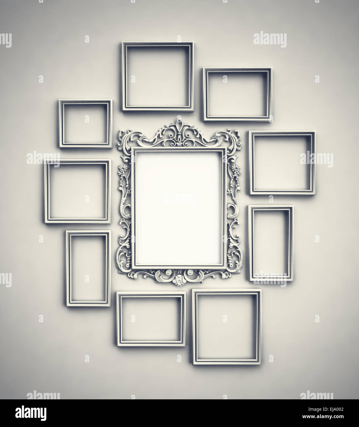 Wall with simple frames surrounding ornamented frame in the middle Stock Photo