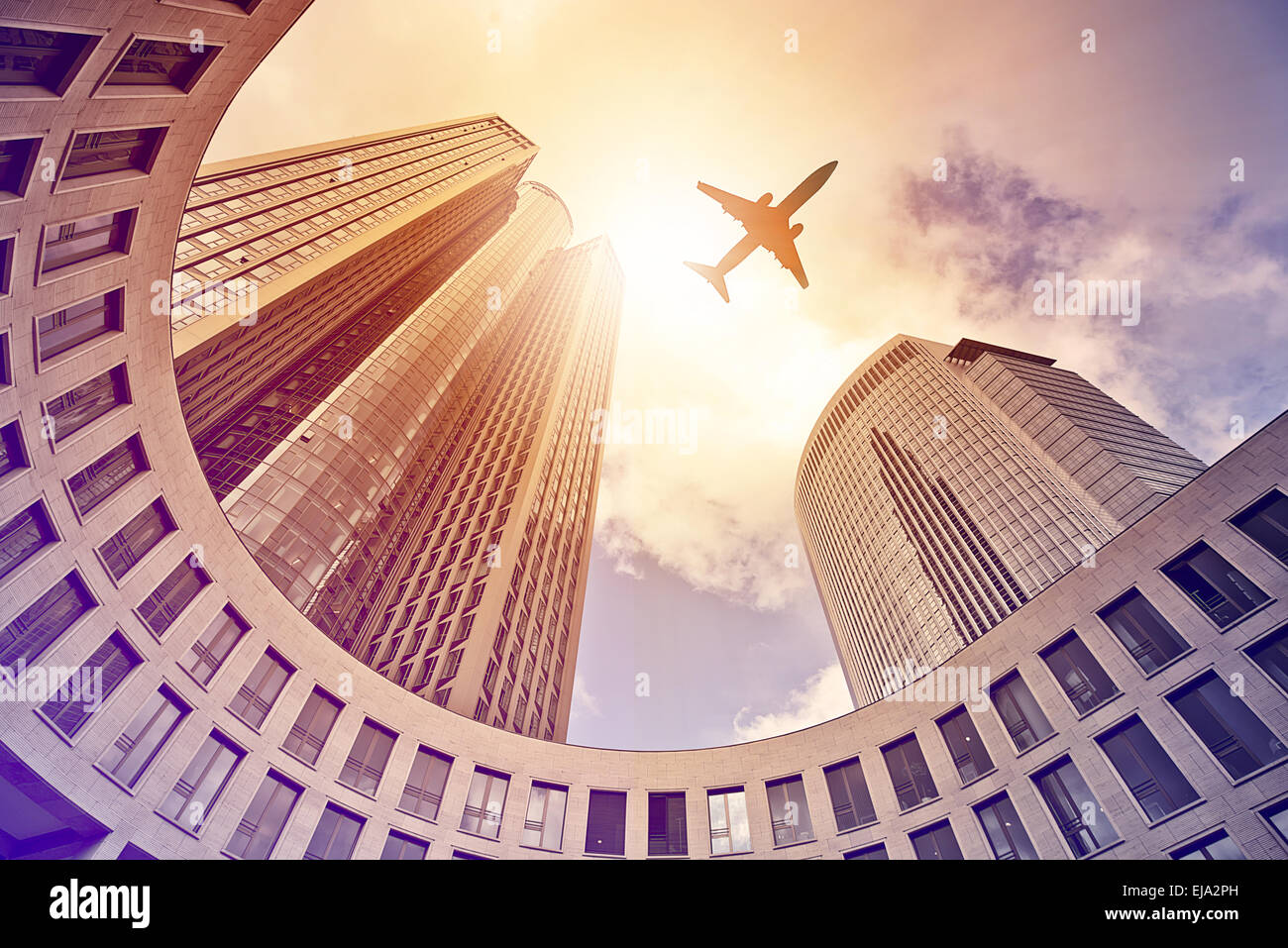 plane flying over modern office towers Stock Photo
