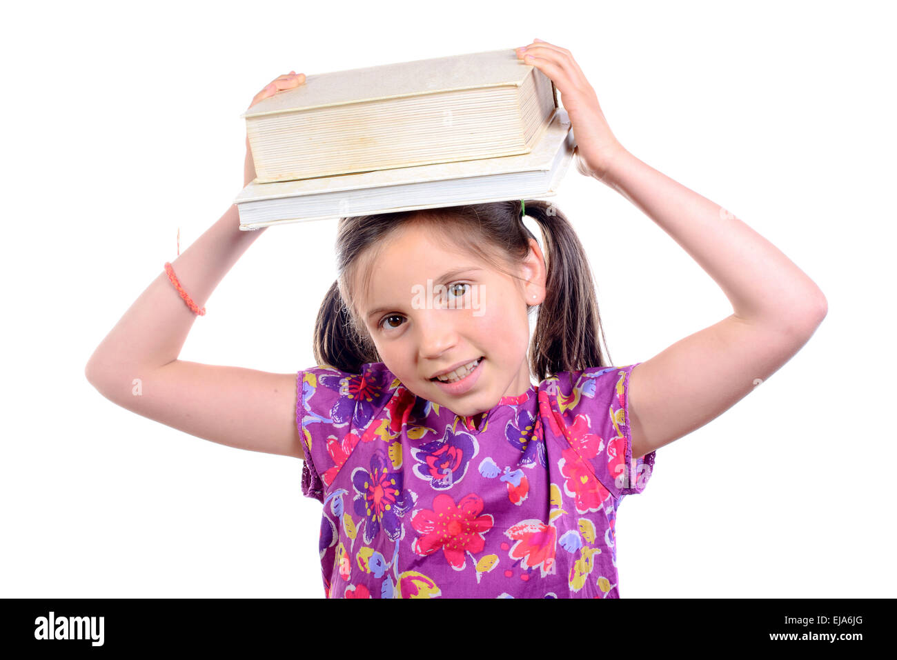 Schoolgirl with pile of books on head on white background Stock Photo ...