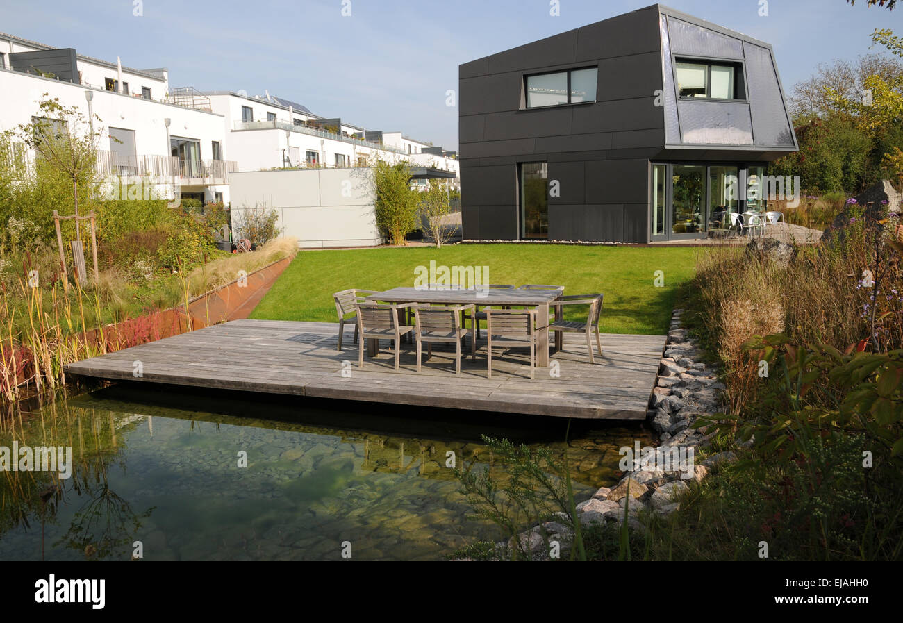 Pond with wooden deck and modern house Stock Photo