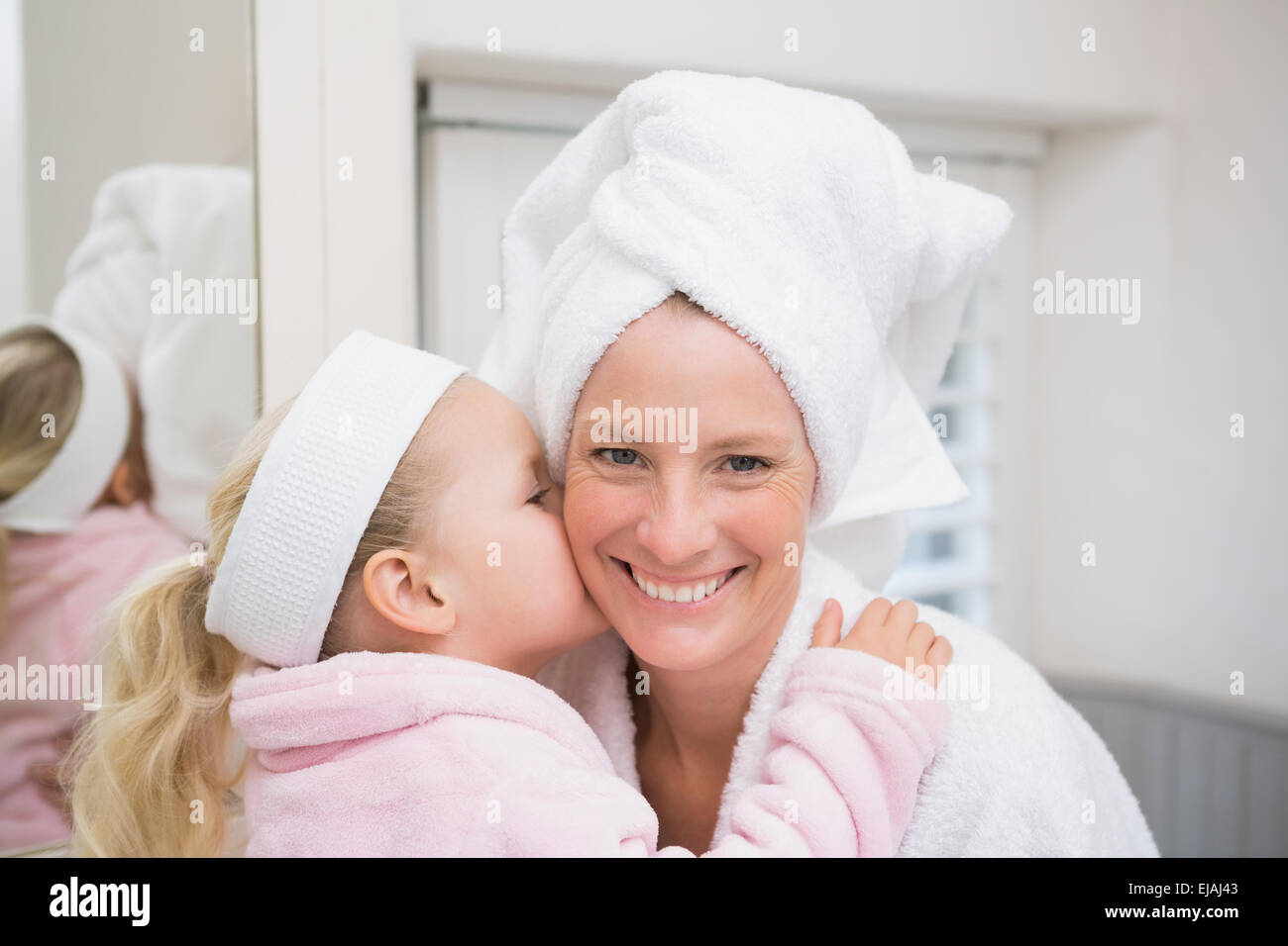 Cute little girl with mother in bathrobes Stock Photo