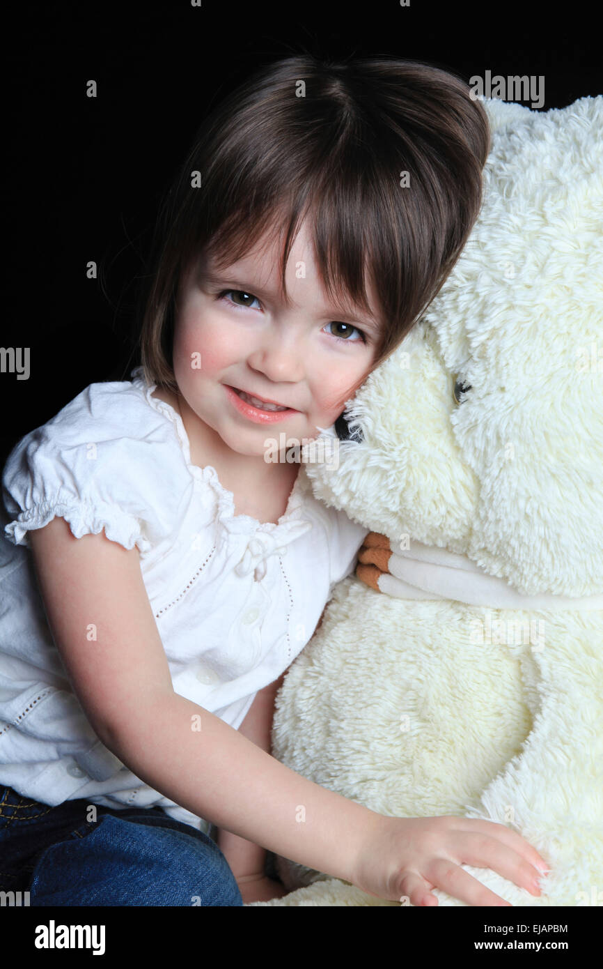little girl with bear on a black background Stock Photo