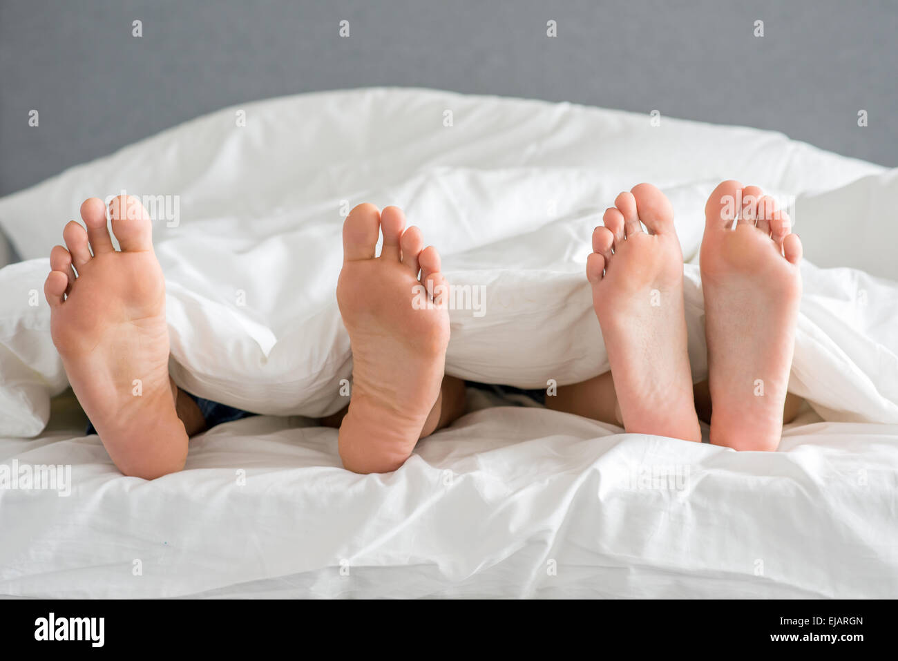 Close up Partners Soles on White Bed Stock Photo