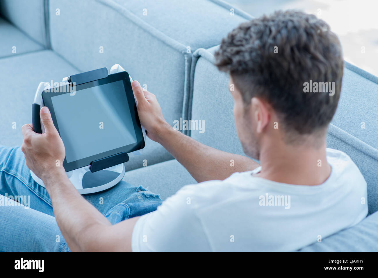 Middle Age Man Using Cool Tablet at Couch Stock Photo