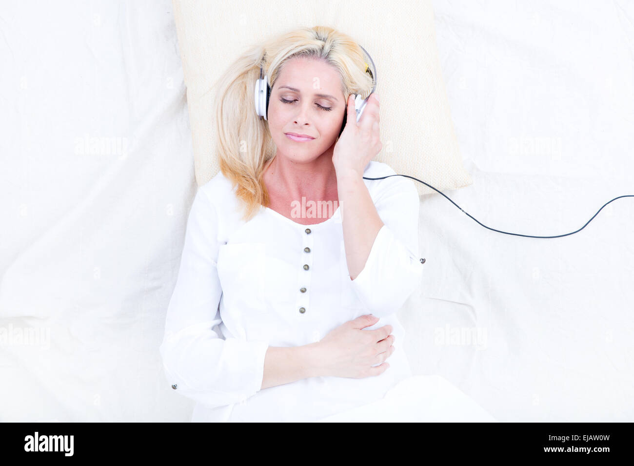 Woman with headphones in Bed Stock Photo Alamy