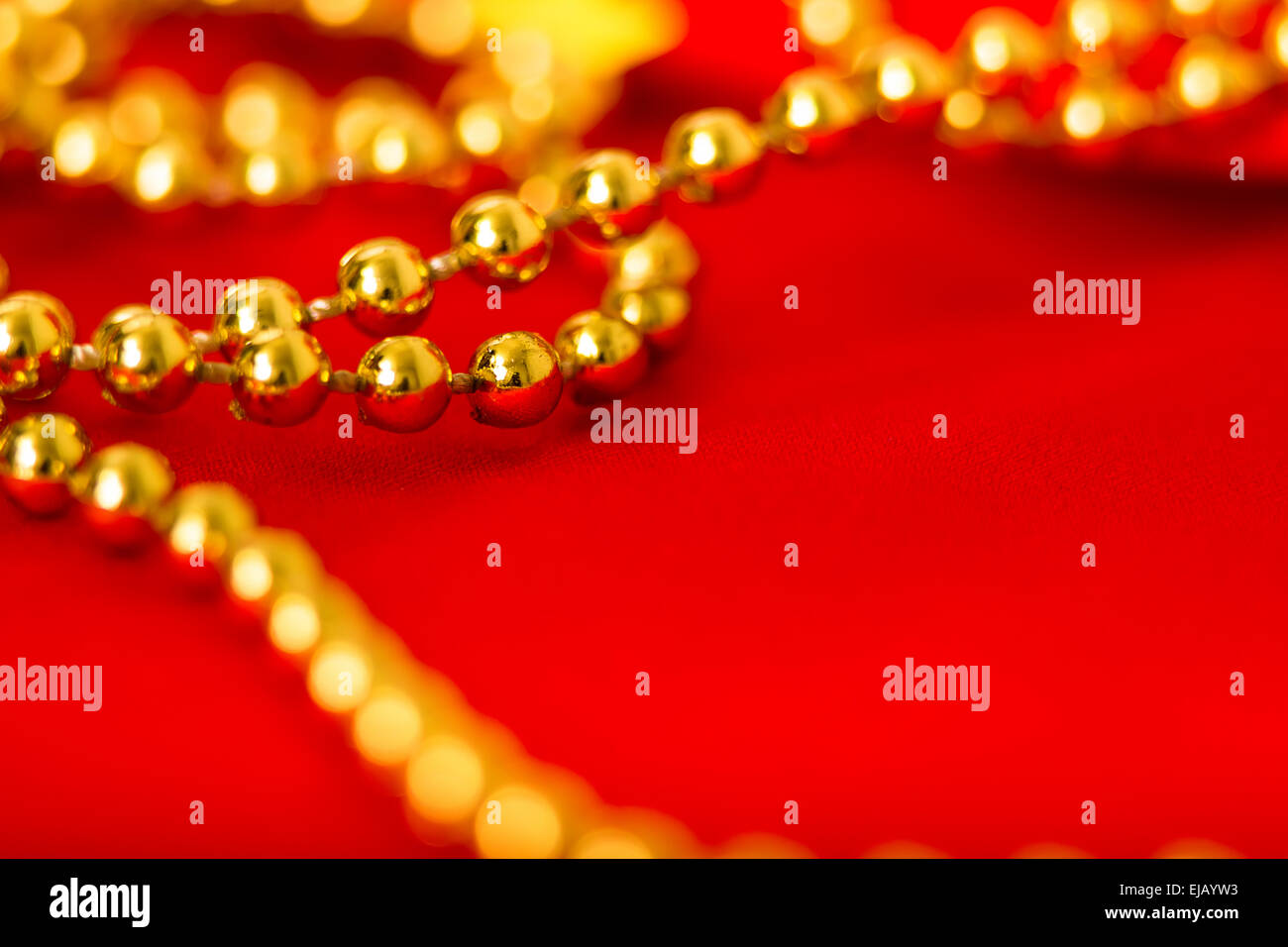 Gold beads on red fabric. macro shooting Stock Photo