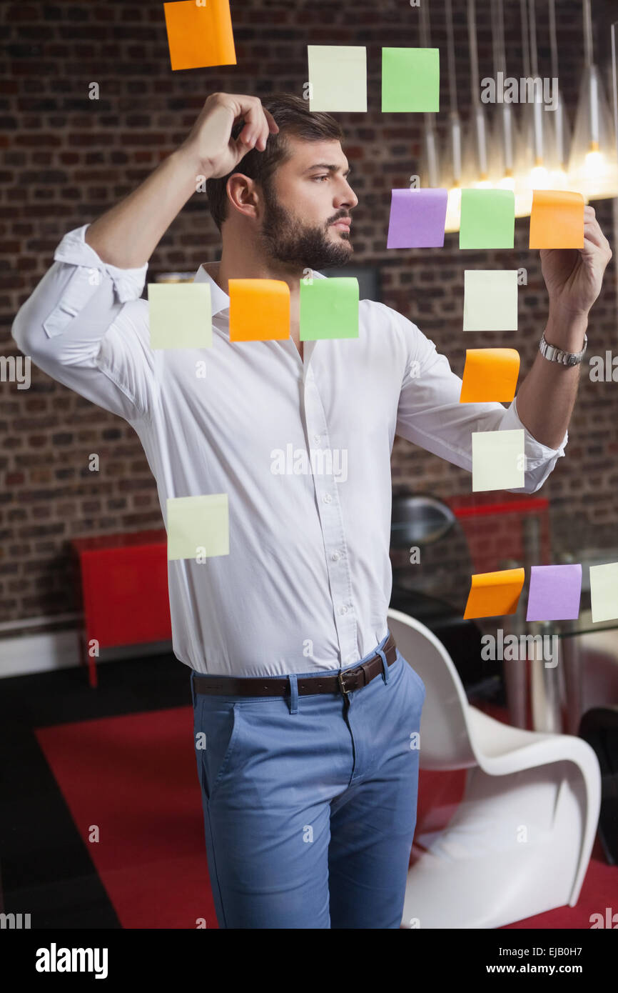 Casual businessman writing on sticky notes Stock Photo - Alamy