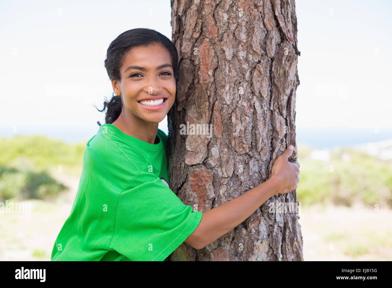 Pretty environmental activist hugging tree Stock Photo