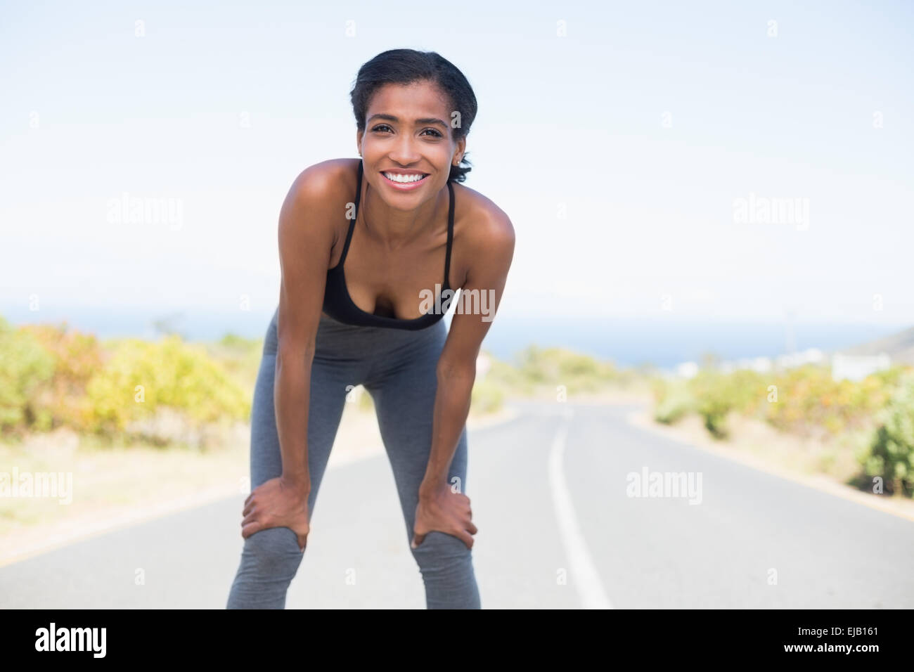 Fit woman taking a break on the open road Stock Photo