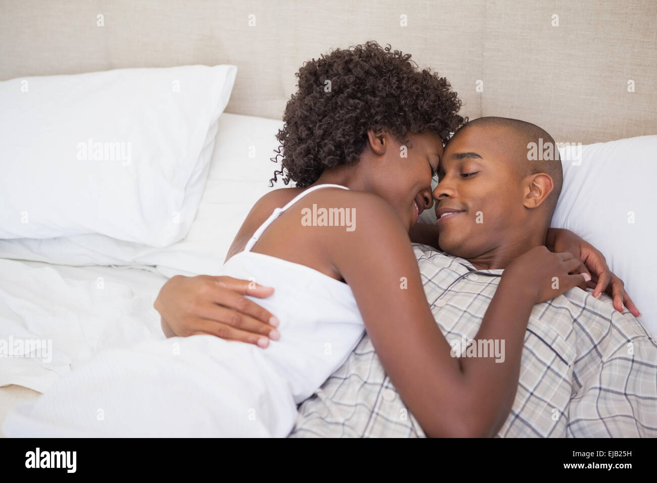 African american couple cuddling in bed hi-res stock photography and ...