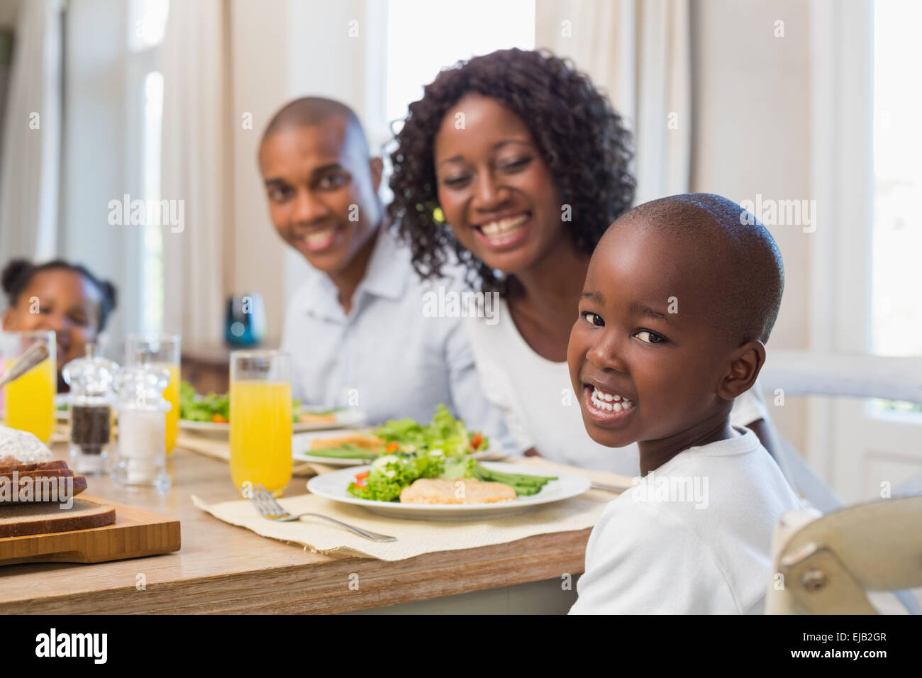 Happy family smiling at camera at lunch Stock Photo