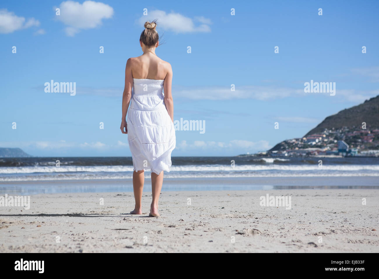 Blonde in white dress walking on the beach Stock Photo - Alamy
