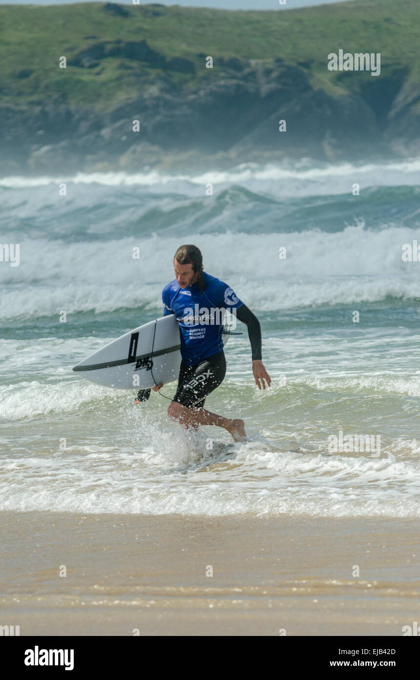 Pro surfer leaves the sea after his round in the surf competition at the Relentless Boardmasters 2014, on Newquay's Fistral beac Stock Photo