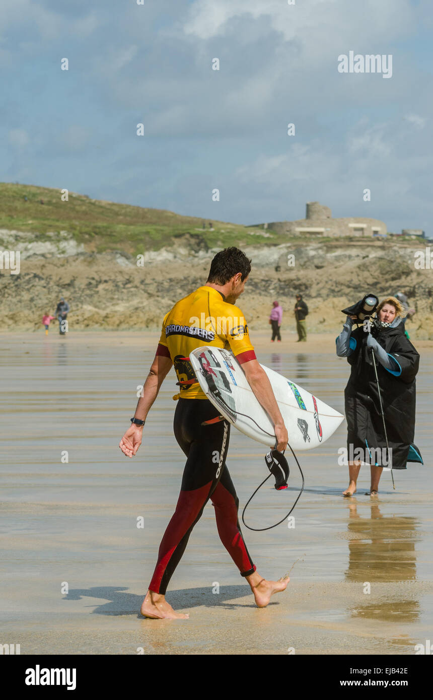 Photographer approaches A pro male surfer after winning his round of the Boardmasters surf competition at Fistral beach Newquay Stock Photo