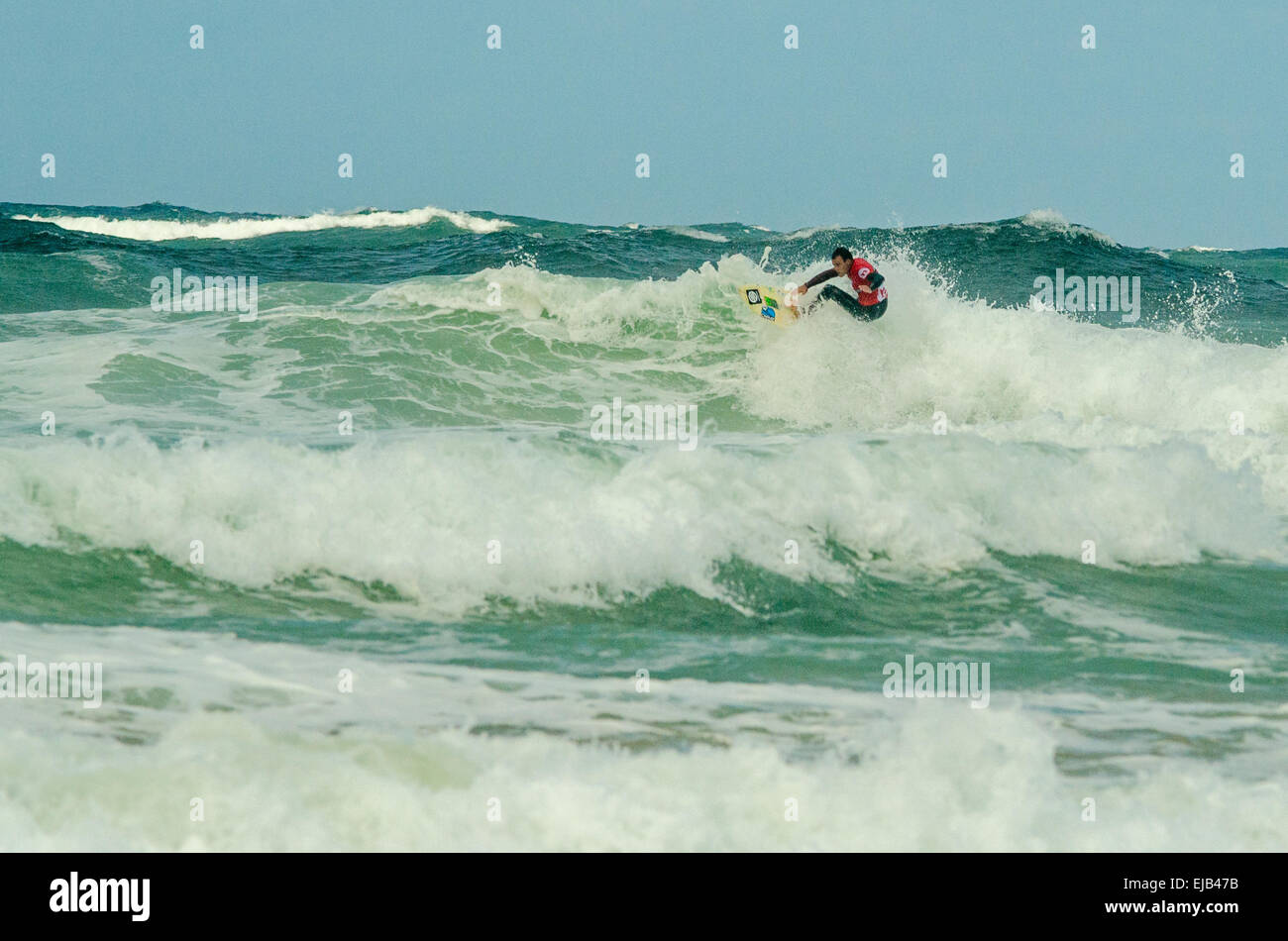 Surfer takes on big waves at newquay's Fistral beach at 2014 Boardmasters open mens semi final Stock Photo