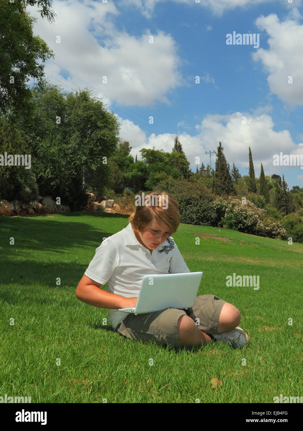 A beautiful blond boy plays on the laptop Stock Photo - Alamy