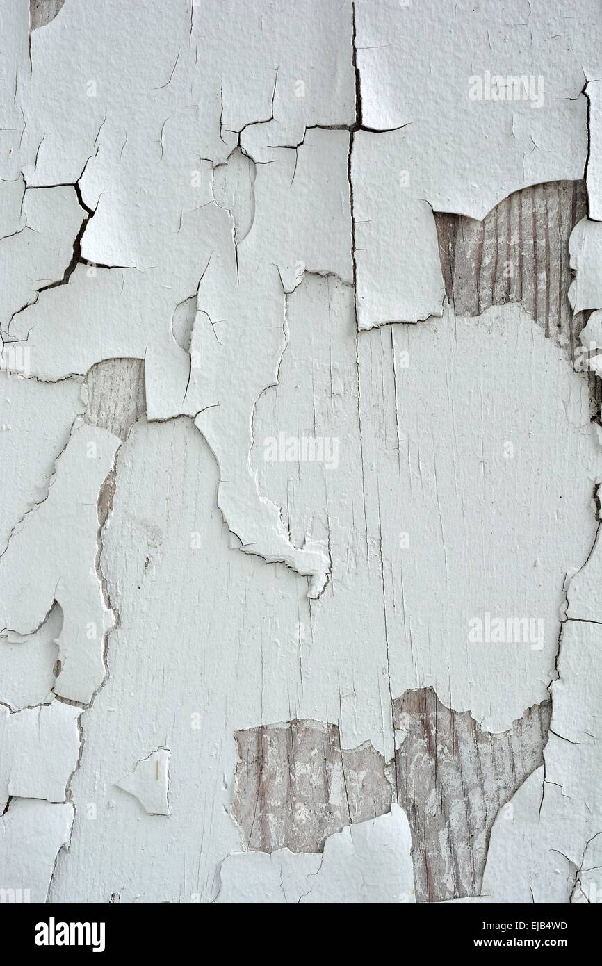 Old flaky white paint peeling off of a wall. Stock Photo