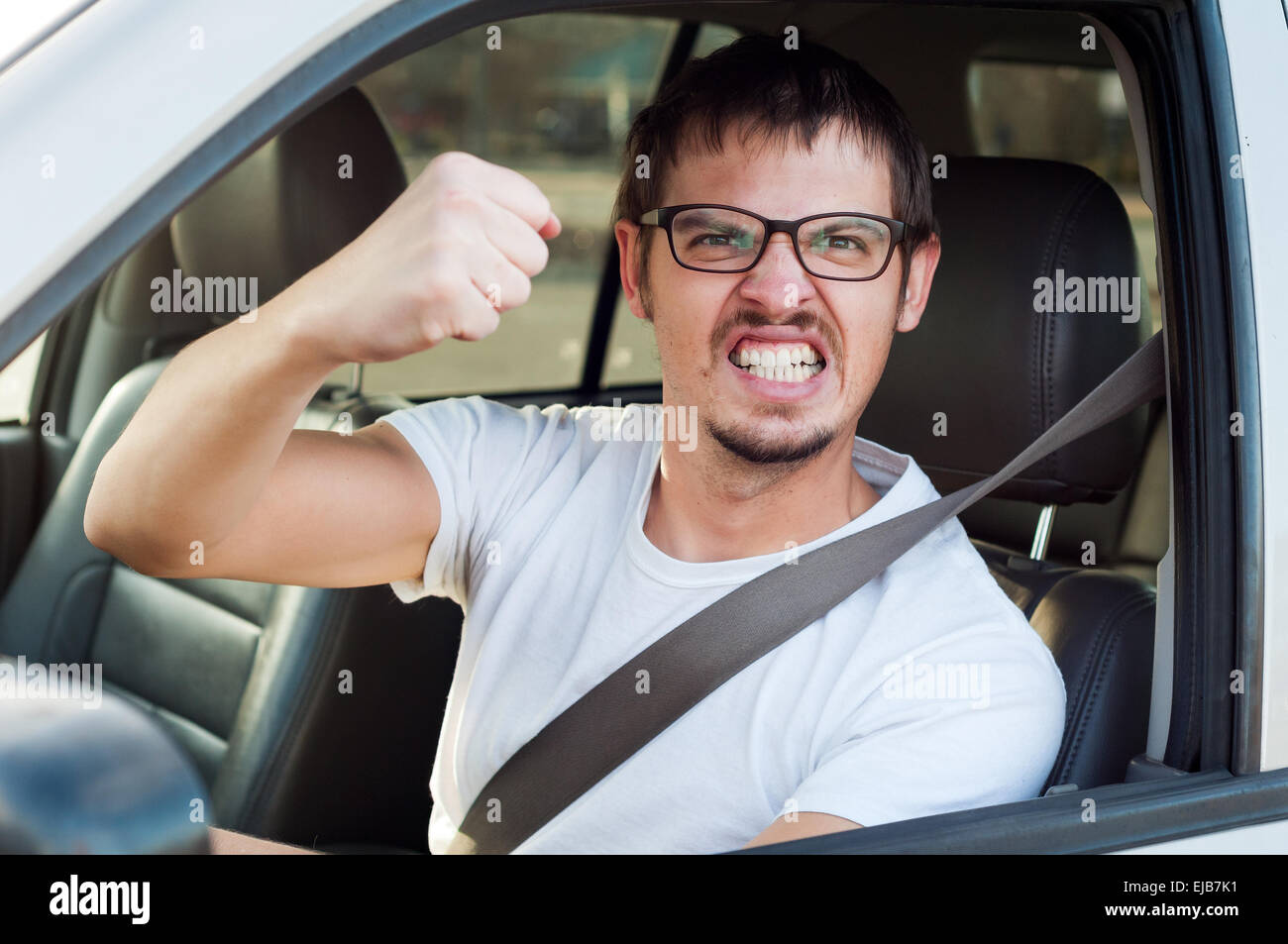 Male caucasian angry driver is showing his fist and mad face Stock