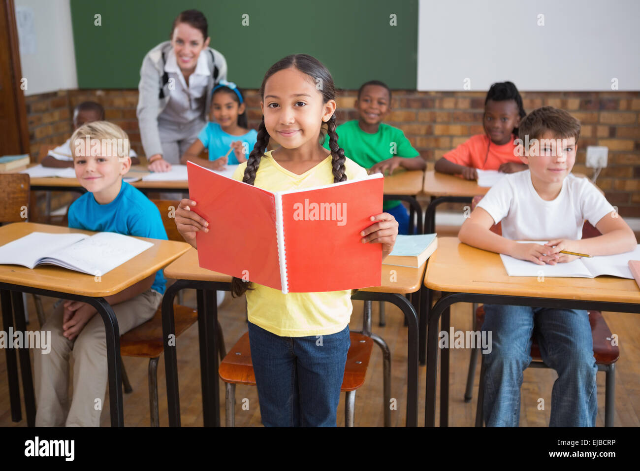 Cute pupils smiling at camera in classroom Stock Photo - Alamy
