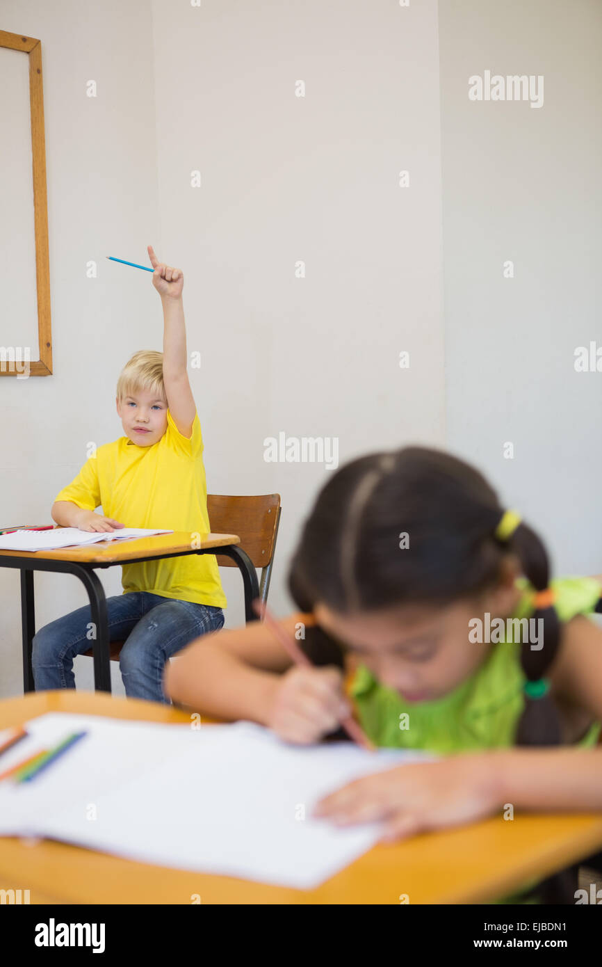 Cute pupils colouring at desks in classroom Stock Photo