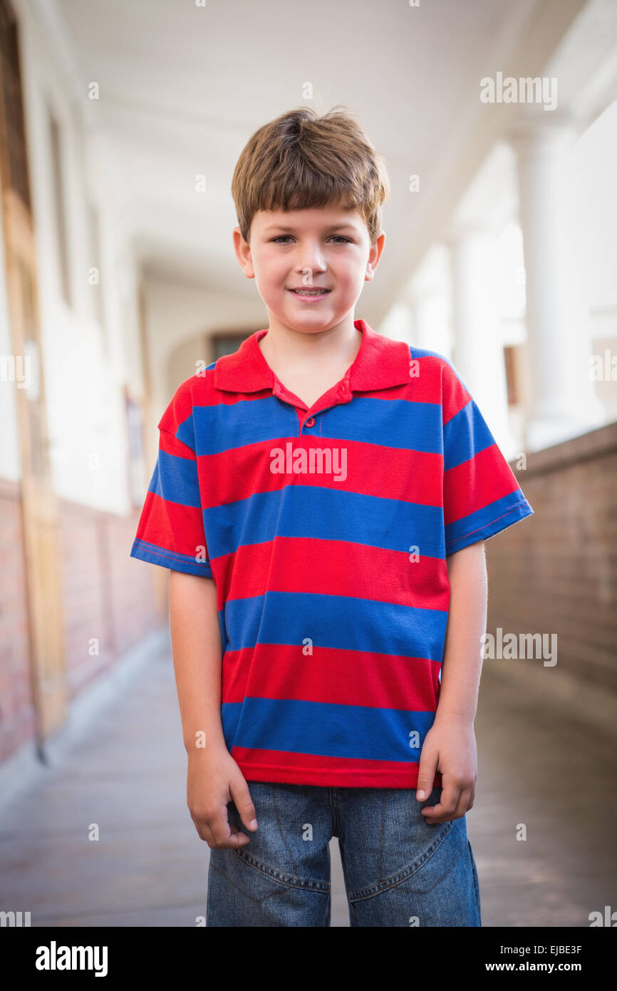 Cute pupil smiling at camera in corridor Stock Photo - Alamy