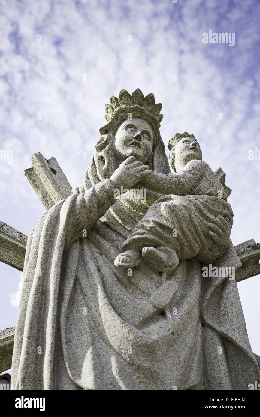 Virgin and child religious stone statue with sky, religion and faith Stock Photo