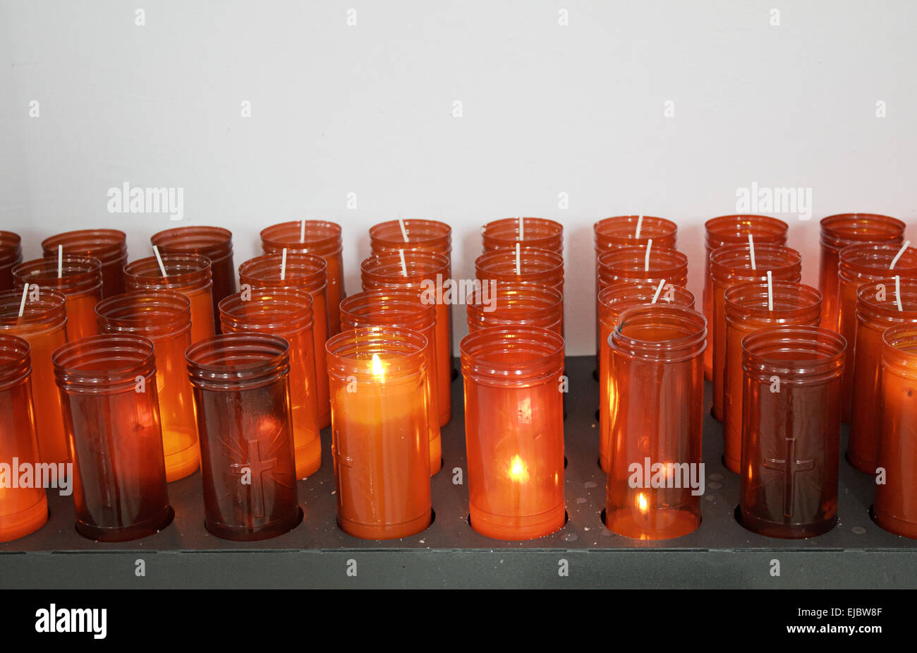 Burning candles with Plastic Container in church offering and lighting