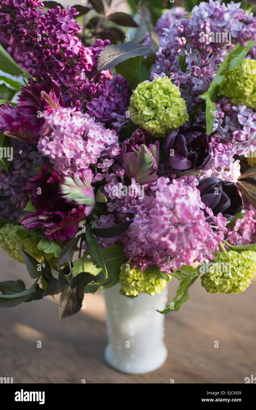 Spring floral bouquet with lilacs, tulips, Snowball bush, hellebore and euphorbia Stock Photo