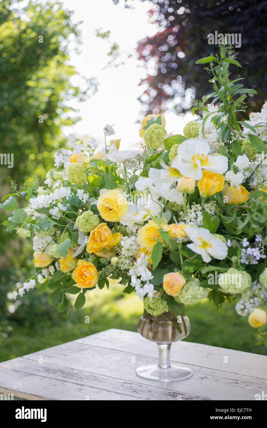 Spring floral arrangement bouquet of yellow roses, white poppies and snowball bush Stock Photo