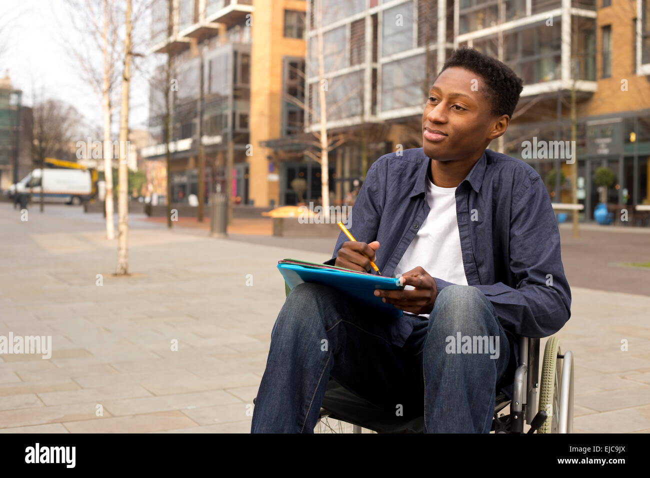 wheelchair bound man looking thoughtful with folders and a pen Stock Photo Alamy
