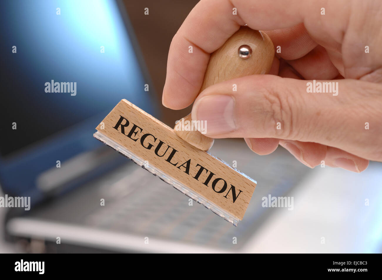 regulations marked on rubber stamp in hand Stock Photo