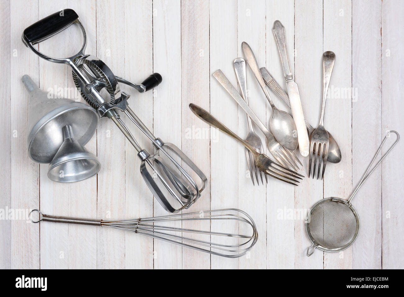 Overhead shot of a group of old kitchen utensils on a rustic wood kitchen table. Stock Photo