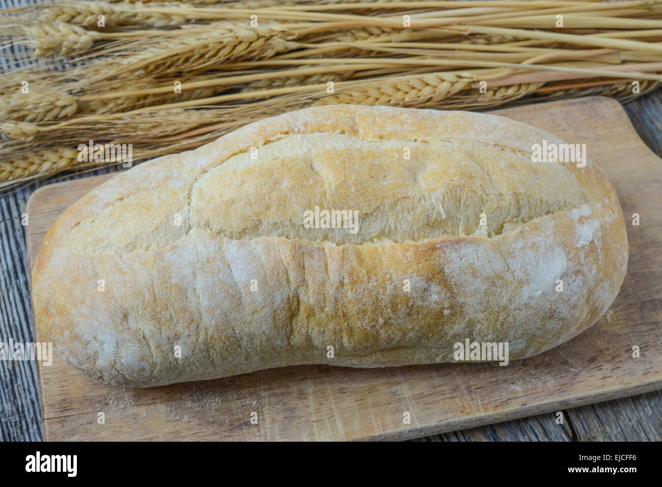 Bread and Wheat on Rustic Wood Background Stock Photo - Alamy