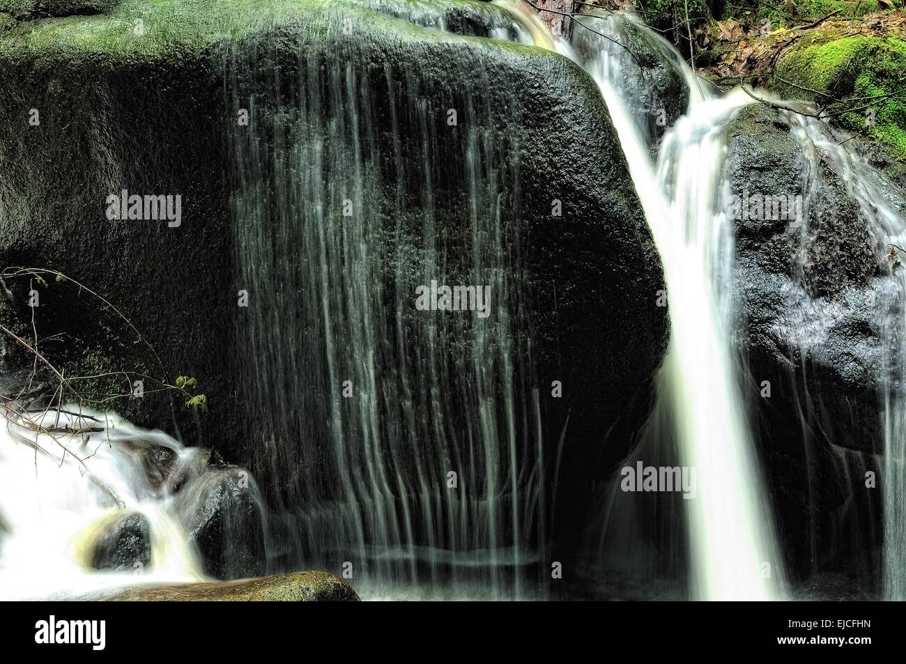 Soft water over the hard granite stone Stock Photo