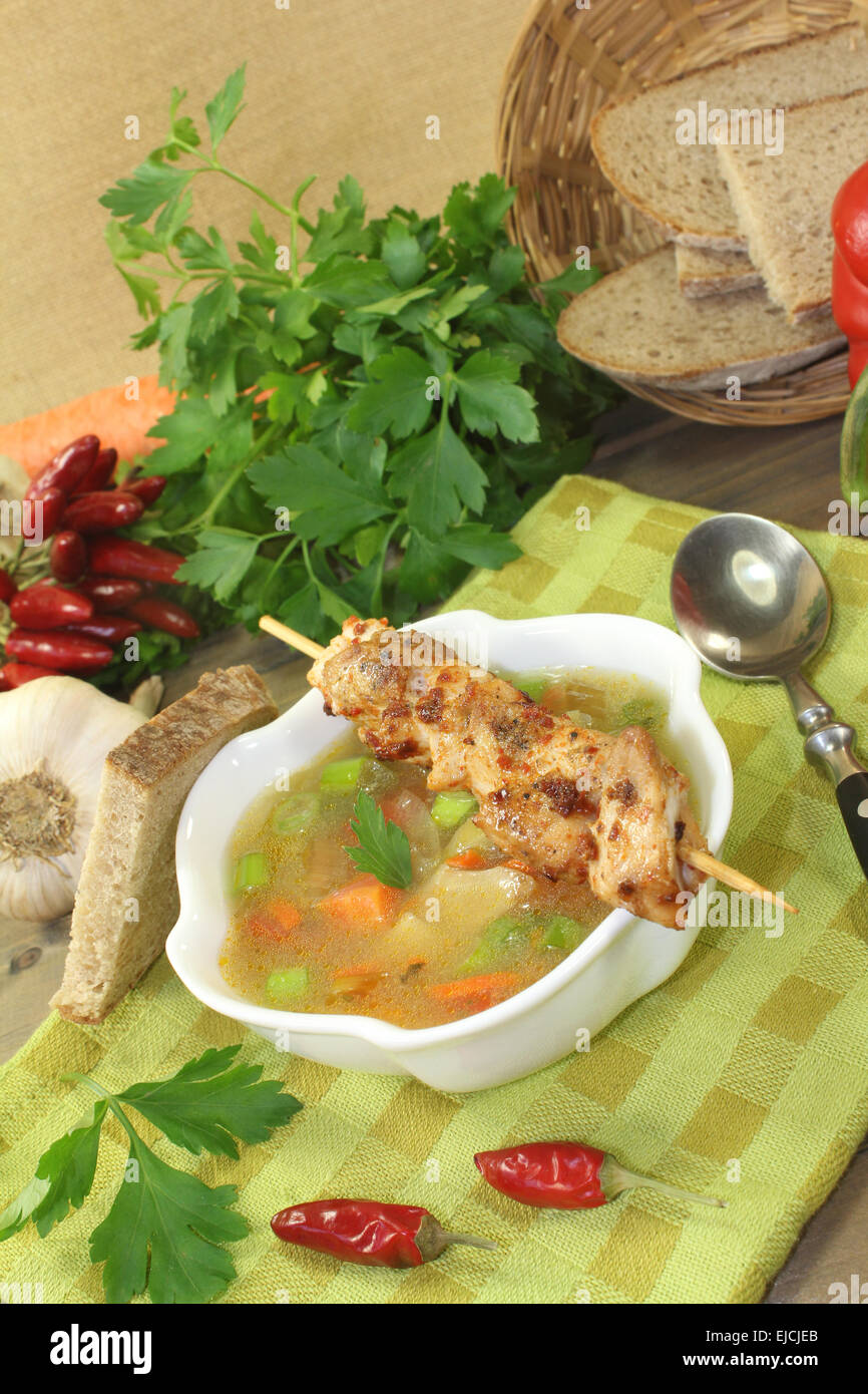 Poultry consomme soup with chicken skewer Stock Photo Alamy