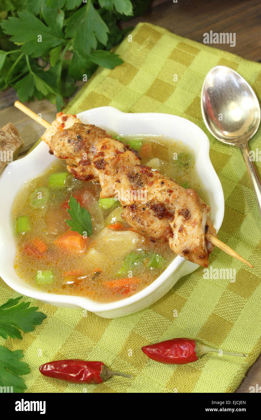 Poultry consomme with chicken skewers Stock Photo Alamy