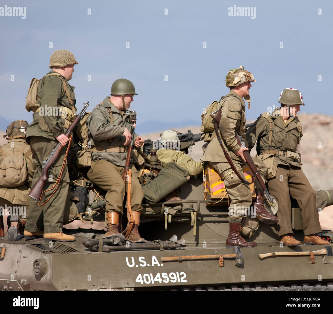 US Army troops sitting on tank wearing World War II uniforms and weapons  during a reenactment demonstration at an air show Stock Photo - Alamy