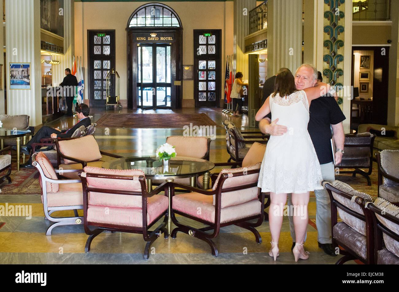 A man and woman hug in the King David Hotel elegant and luxurious lobby. The hotel has hosted many important dignitaries in its rich history including President Bush, Prince Charles, Prince Phillip, Ben Kingsley and Mohammed Ali. Jerusalem, Israel. 19-June-2012. Stock Photo