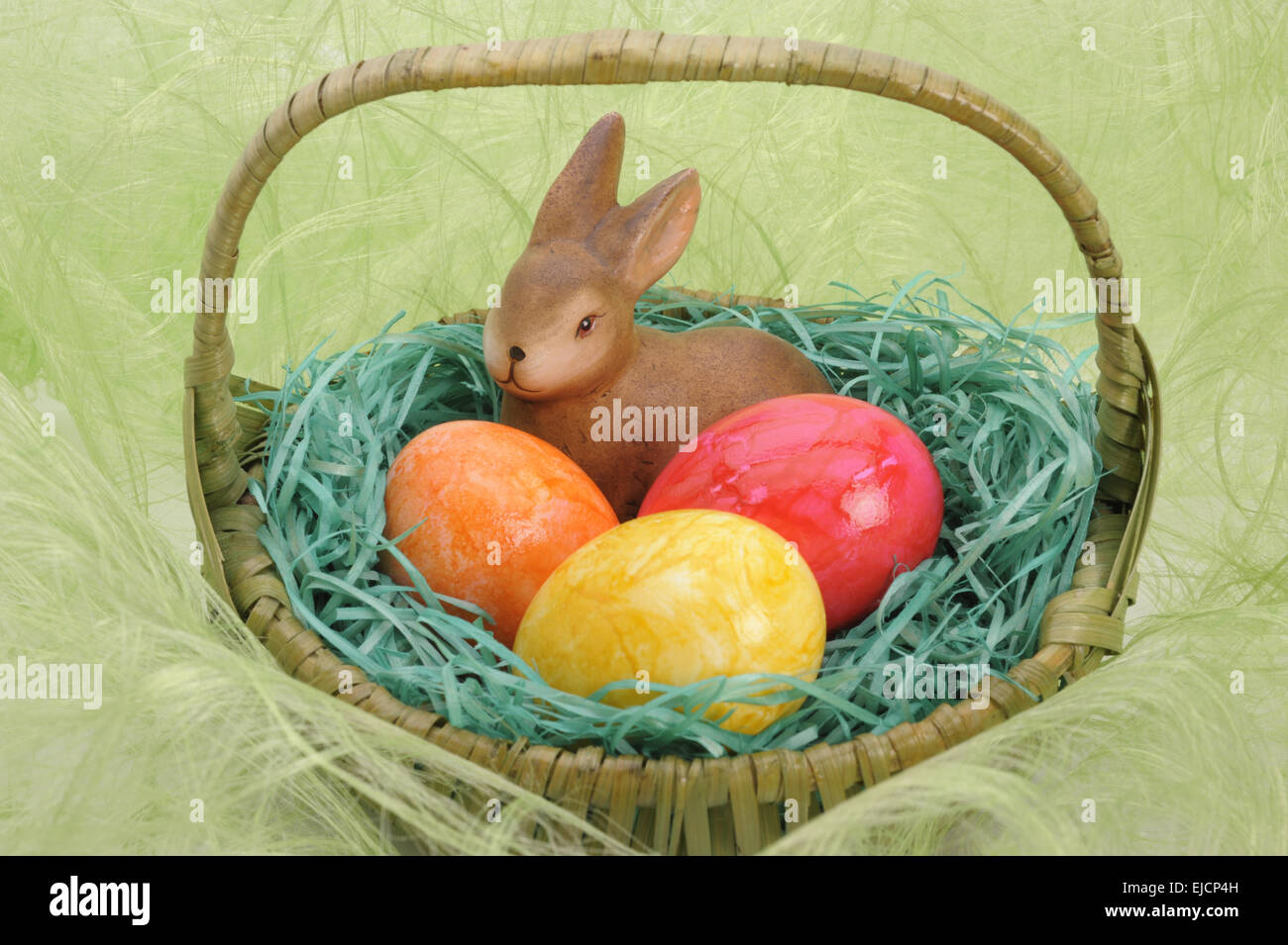 colored easter eggs with rabbit in nest Stock Photo