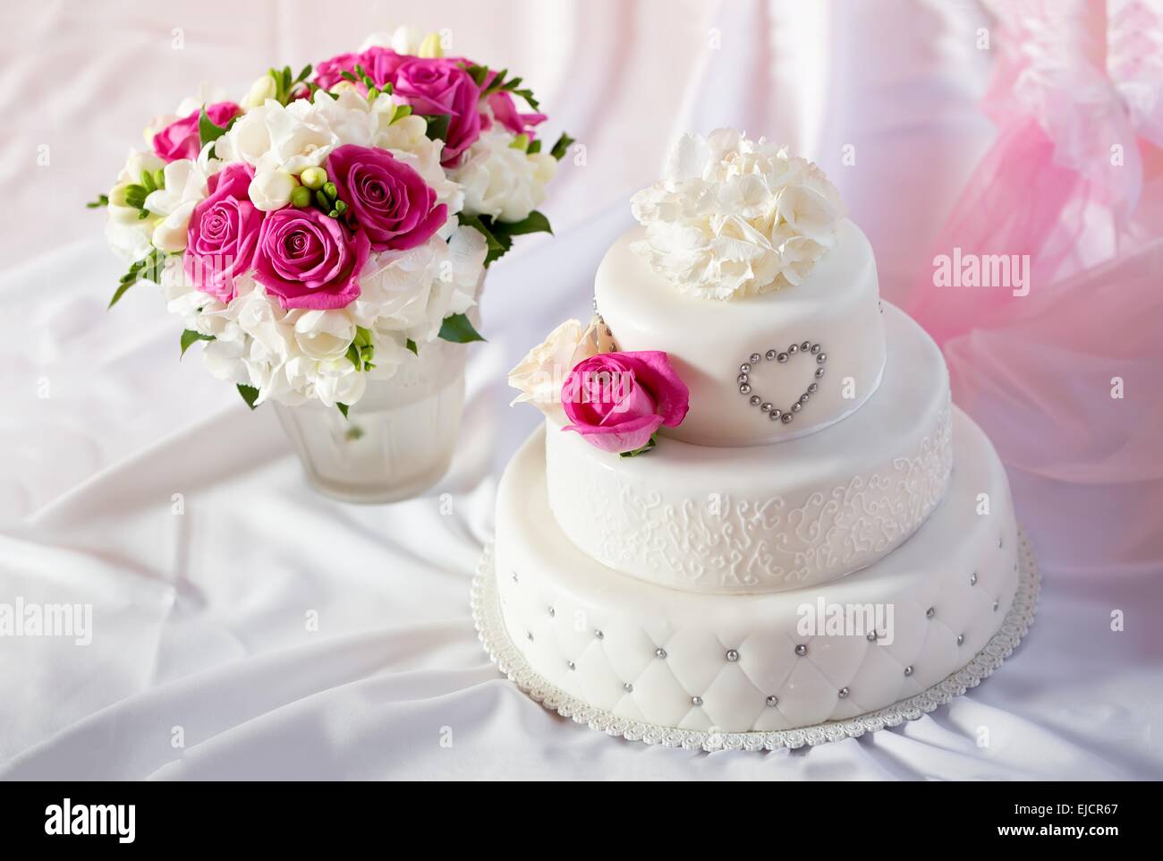Traditional wedding cake and bridal bouquet Stock Photo