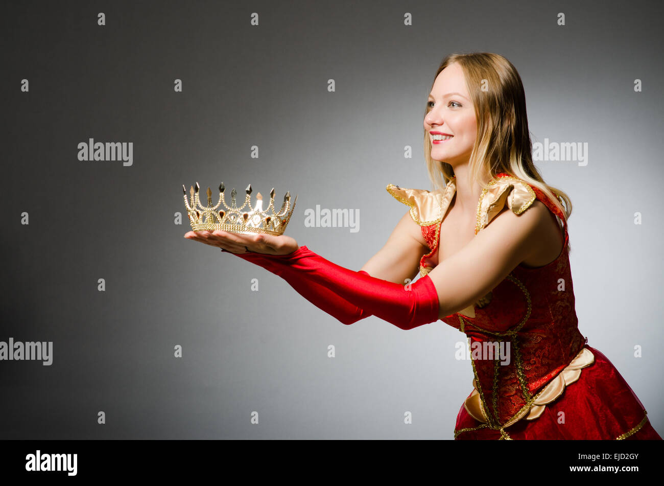 Queen in red costume against dark background Stock Photo - Alamy